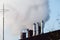 Multiple coal fossil fuel power plant smokestacks emit carbon dioxide pollution of environment and air