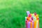 Multiple color drinking straws on a green grass background blur