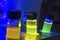 Multiple colourful close up light induced catalyst photochemical reaction in glass vial under UV light in a dark chemistry