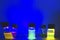 Multiple colourful close up photochemical reaction in glass vial under blue UV light in a dark chemistry laboratory