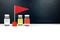Multiple Covid-19 vaccine vials beside a red flag. Coronavirus vaccine candidate development race and competition concept.