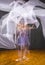 Multiple exposure of ballerina in purple, dancing with white fabric