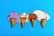 Multiple flavor ice cream cones melted on blue background