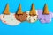 Multiple flavor ice cream cones melted on blue background