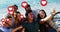Multiple heart icons floating against group of friends taking a selfie