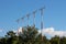 Multiple high metal red and white poles with airport runway guiding lights surrounded with dense trees