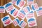 Multiple I Voted stickers on table - concept of voter fraud showing many I voted stickers.