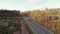 Multiple lane speedway with cars and trucks in beautiful fall forest. Speedy highway with cars driving through autumn forest with