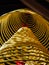 Multiple large yellow incense coils hanging in stacks from the ceiling in a Chinese temple