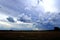 Multiple Layers of Storm Clouds Over Flat Farm Field