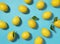 Multiple lemons placed on a blue background