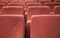 Multiple red theater chairs in row