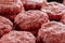 Multiple stacks of freshly processed raw hamburger patties on display in meat processing plant