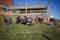 Multiple strollers in field with building behind