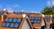 Multiple town house rooftops with solar panels.