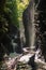 Multiple waterfalls on the Gorge trail in Watkins Glen state park, New York. Sunlight reflections on the wet rocky bank