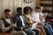 Multiracial black and white people sitting on couch using device