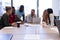 Multiracial businessmen and businesswomen discussing strategy during meeting in boardroom at office