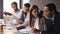 Multiracial colleagues sitting in coworking office working together using laptop