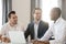 Multiracial colleagues sitting at desk during meeting laughing having fun