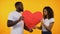 Multiracial couple holding two parts of paper heart, breakup relationship crisis