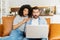 Multiracial couple with a laptop on the couch