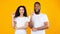 Multiracial Couple Pointing Fingers Up Having Idea Over Yellow Background