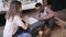 Multiracial couple sitting on the floor in pajamas and playing the board game together. Man throw the dice and take card