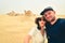 Multiracial couple taking selfie at fossil desert in Abu Dhabi, UAE. Fun time together concept alternative fashion travelers,