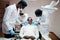 Multiracial dentist doctors team. African american man patient at UV protective glasses. His teeth treated with the help of a