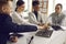 Multiracial diverse business team putting hand together sitting at office desk