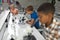Multiracial elementary students looking in microscope during science practical in laboratory