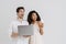 Multiracial excited couple posing with laptop and credit card