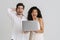 Multiracial excited couple posing with laptop and screaming