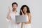 Multiracial excited couple posing with laptop and screaming