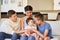 Multiracial family at home. Mother with her adoptive sons. Young mixed race mother relaxing with her children. Diverse