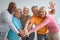 Multiracial group of athletic senior people placing hands