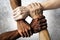 Multiracial group with black african American Caucasian and Asian hands holding each other wrist in tolerance unity love and anti