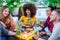 Multiracial group of friends enjoying mojito in a bar restaurant at sunset in summer making a toast.Young people hands holding