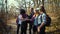 Multiracial group of hikers deciding on direction in autumn forest