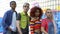 Multiracial group of teenagers looking camera on graffiti wall background, style