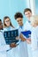 A multiracial group of young medical interns listening to a elder doctor in a