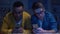 Multiracial male friends surfing net late at night, gadget addiction, eyesight