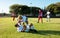 Multiracial male player assisting injured teammate lying on field in getting up during match