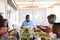 Multiracial multigeneration family eating lunch while sitting at dining table at home