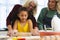 Multiracial multigeneration female family kneading dough with rolling pin on table in kitchen