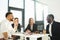 Multiracial office workers at morning meeting in office.