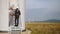 Multiracial partners standing on stairs near wind turbine and looking on screen of digital tablet. Two industrial