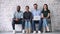 Multiracial people sitting on chairs holding devices looking at camera