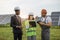 Multiracial people standing at solar farm and talking